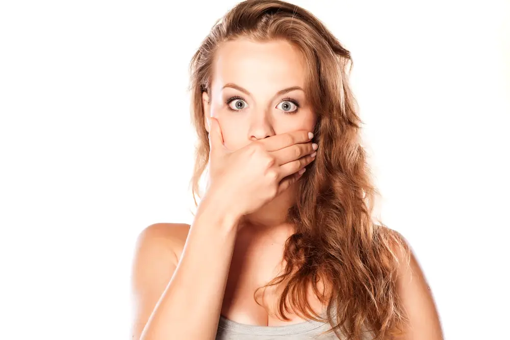 woman with bad breath covering mouth